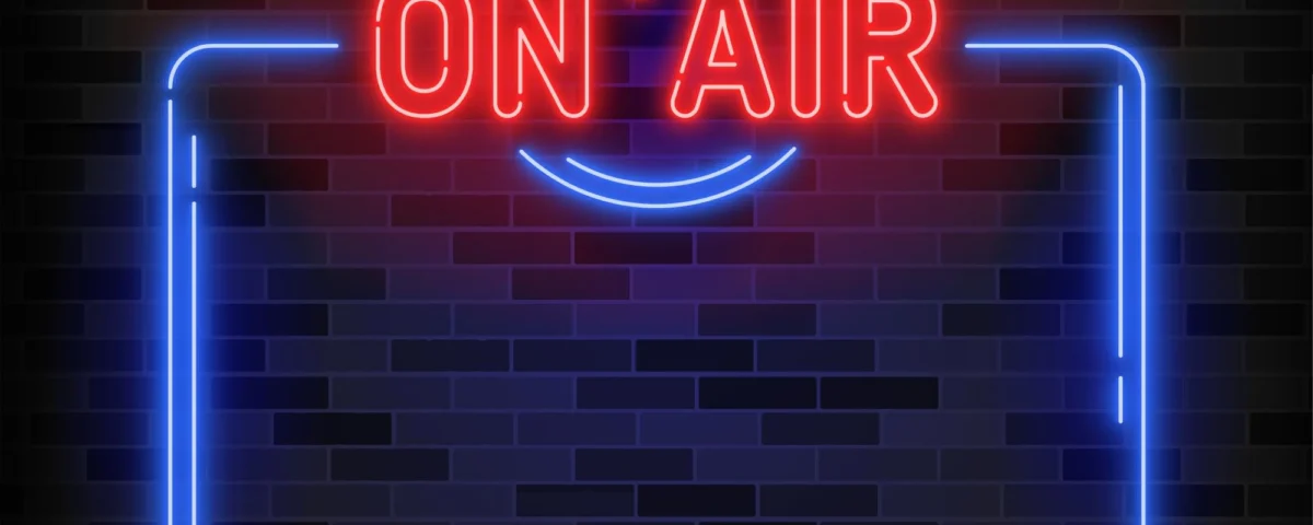 ON AIR" poster in red and blue neon on a brick background with technical diagram in the background